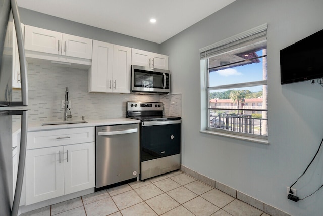 kitchen featuring light tile patterned floors, dishwasher, decorative backsplash, stove, and sink