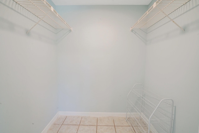 walk in closet with light tile patterned floors