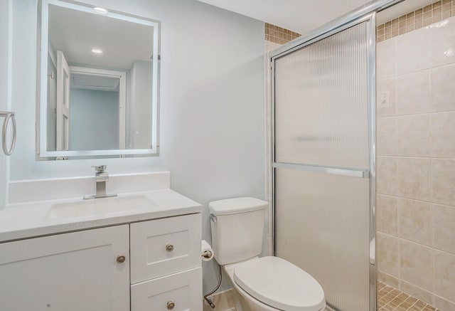 bathroom with vanity, a shower with shower door, and toilet