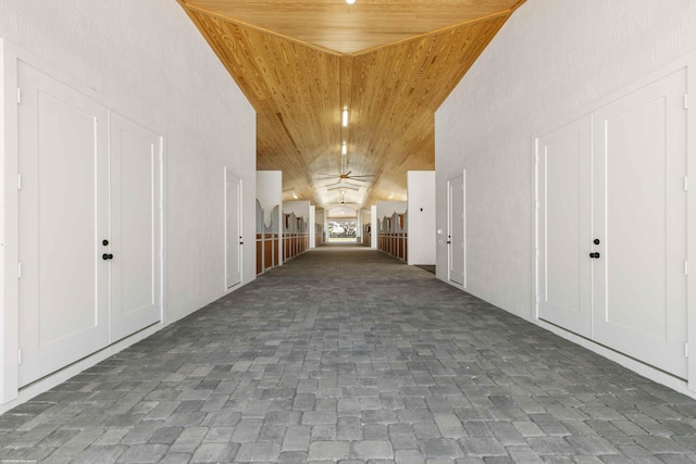 corridor featuring high vaulted ceiling and wooden ceiling