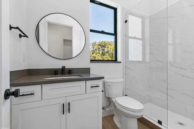 bathroom with toilet, hardwood / wood-style flooring, vanity, and a wealth of natural light