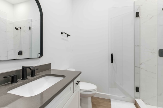 bathroom featuring vanity, toilet, walk in shower, and wood-type flooring