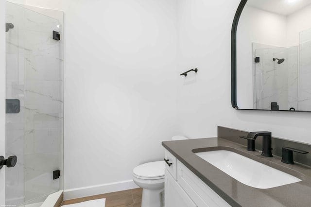 bathroom featuring toilet, an enclosed shower, vanity, and wood-type flooring