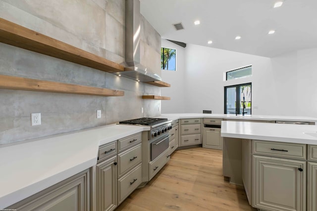 kitchen with a wealth of natural light, backsplash, light hardwood / wood-style floors, and wall chimney exhaust hood