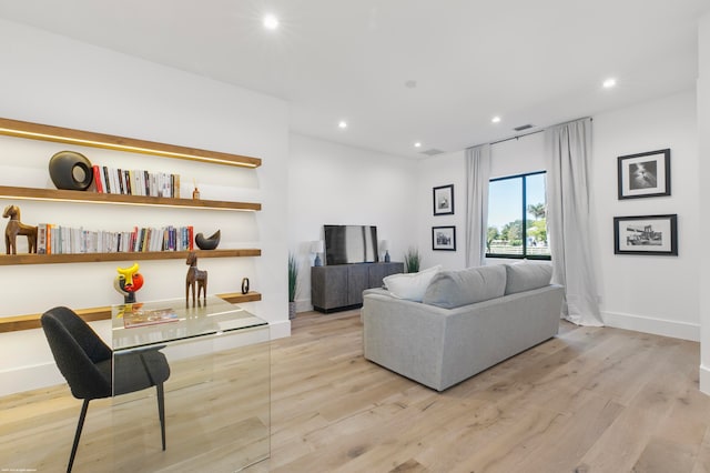 living room with built in desk and light hardwood / wood-style flooring