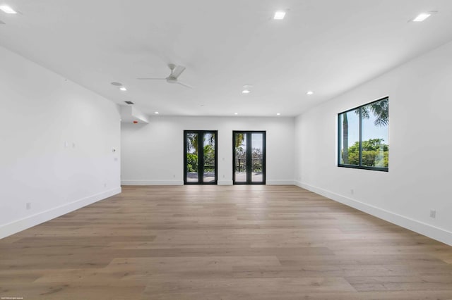 spare room with ceiling fan, light wood-type flooring, and a wealth of natural light