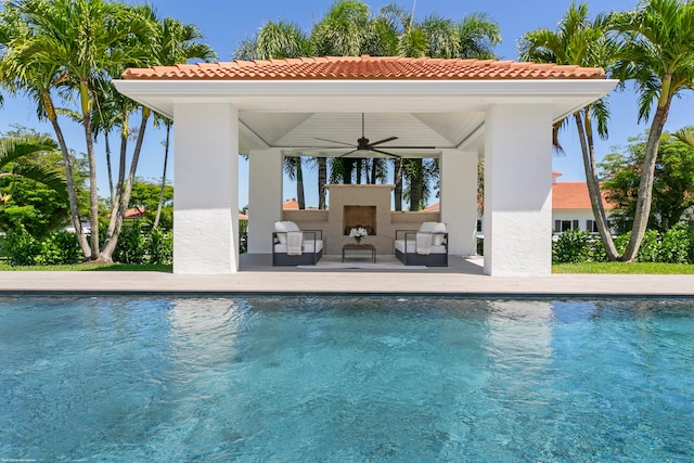 view of pool featuring a patio area, exterior fireplace, and ceiling fan