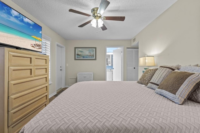 bedroom with ceiling fan, visible vents, a textured ceiling, and ensuite bathroom