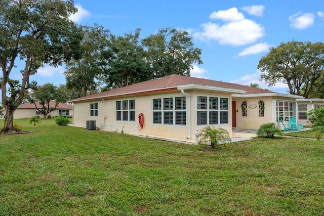 rear view of property featuring a patio area, central air condition unit, and a lawn