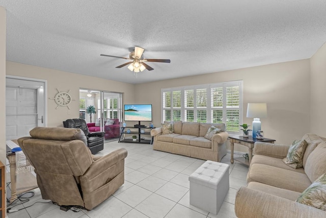 living room featuring a textured ceiling, light tile patterned flooring, and a ceiling fan