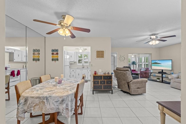 dining area with a textured ceiling and light tile patterned flooring