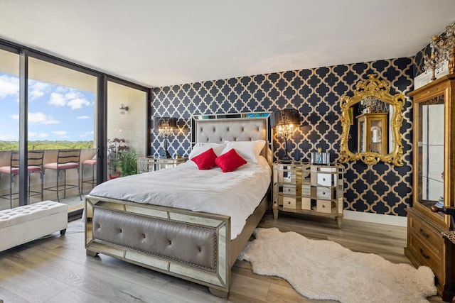 bedroom featuring expansive windows and dark wood-type flooring