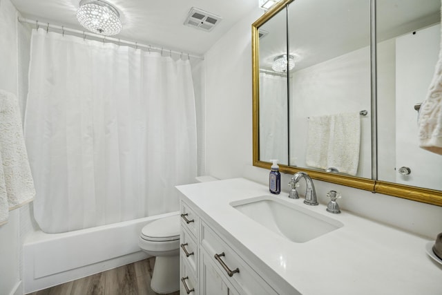 full bathroom featuring vanity, a notable chandelier, shower / bathtub combination with curtain, toilet, and hardwood / wood-style flooring