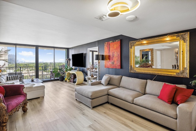 living room featuring floor to ceiling windows and light hardwood / wood-style floors