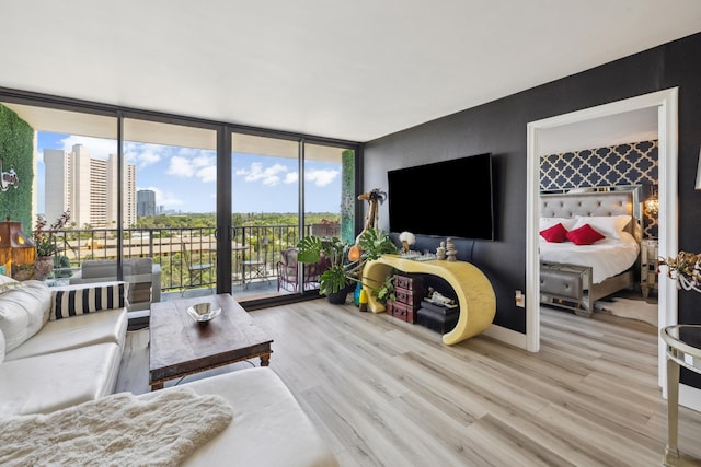 living room with expansive windows and light hardwood / wood-style flooring