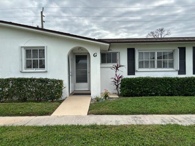 property entrance with a lawn