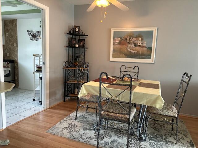 dining space with ceiling fan and light hardwood / wood-style floors