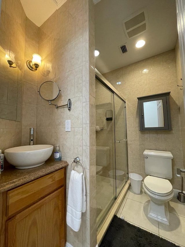 bathroom with vanity, tile floors, toilet, and tile walls