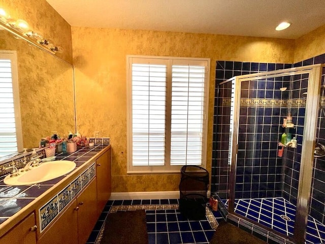 bathroom featuring tile flooring, large vanity, an enclosed shower, and a wealth of natural light