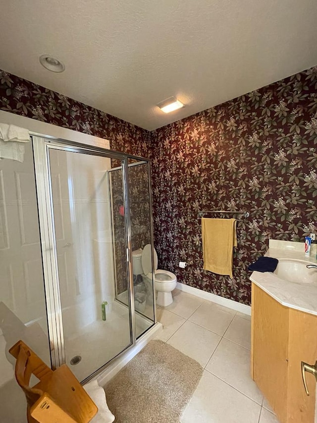 bathroom featuring toilet, a shower with door, tile flooring, a textured ceiling, and vanity