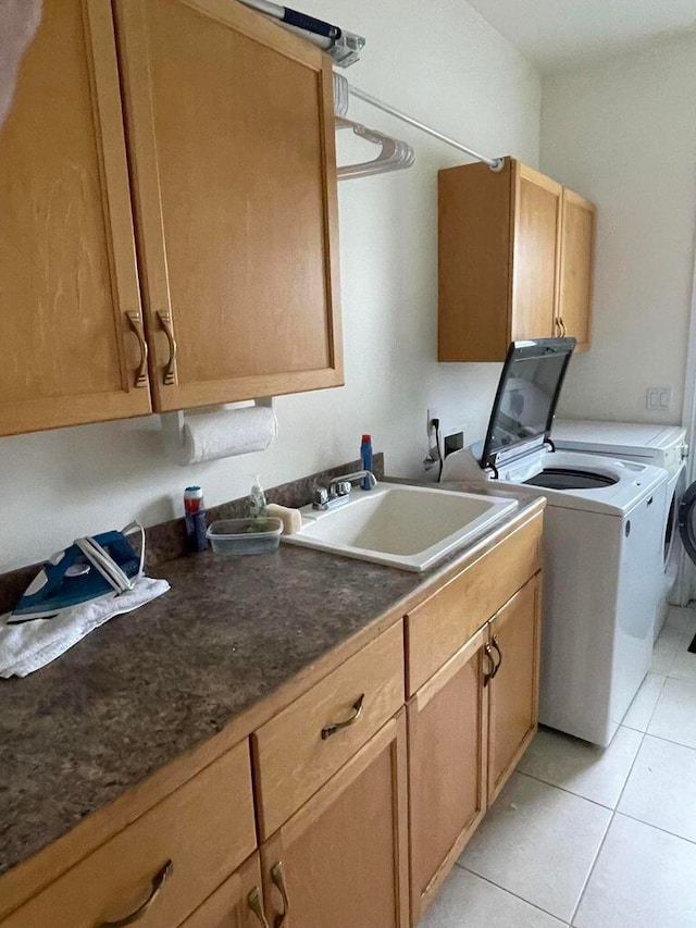 laundry room featuring washer and clothes dryer, cabinets, sink, and light tile floors