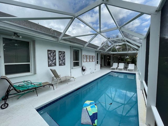 view of swimming pool featuring a lanai and a patio area