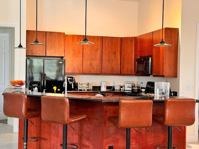 kitchen featuring light tile floors, stove, a breakfast bar, hanging light fixtures, and stainless steel refrigerator with ice dispenser