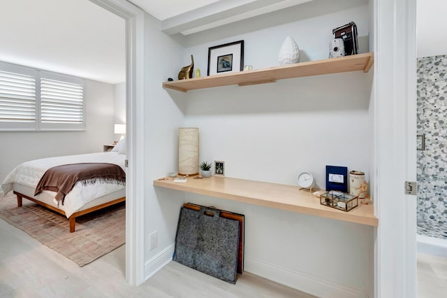 bedroom featuring built in desk and light wood-type flooring