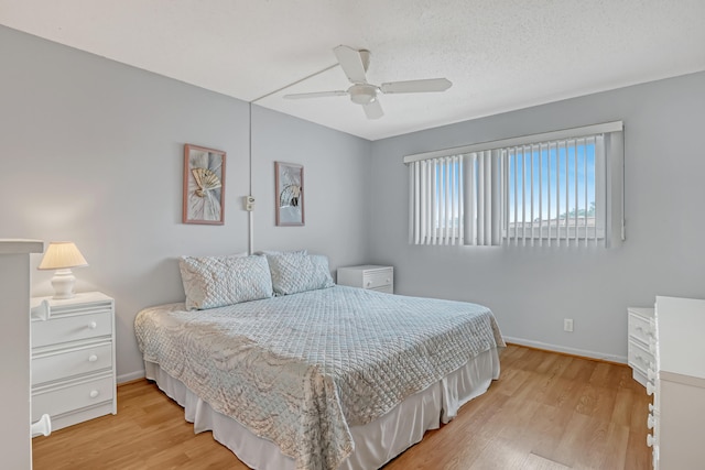 bedroom featuring ceiling fan, a textured ceiling, and light hardwood / wood-style flooring