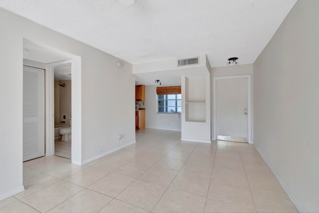 tiled spare room with a textured ceiling