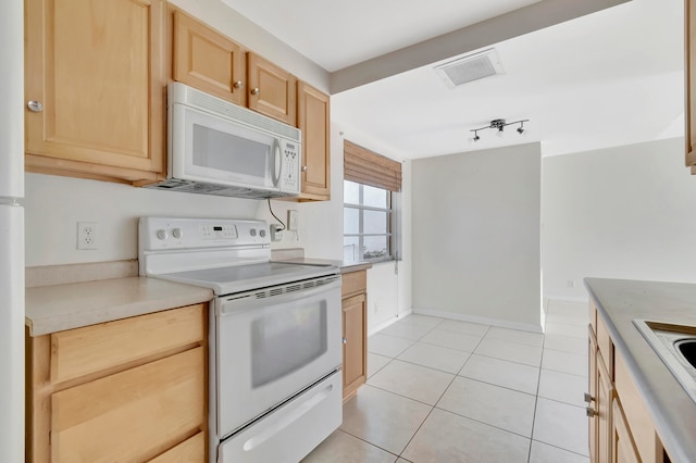 kitchen featuring light tile patterned floors, light brown cabinets, and white appliances