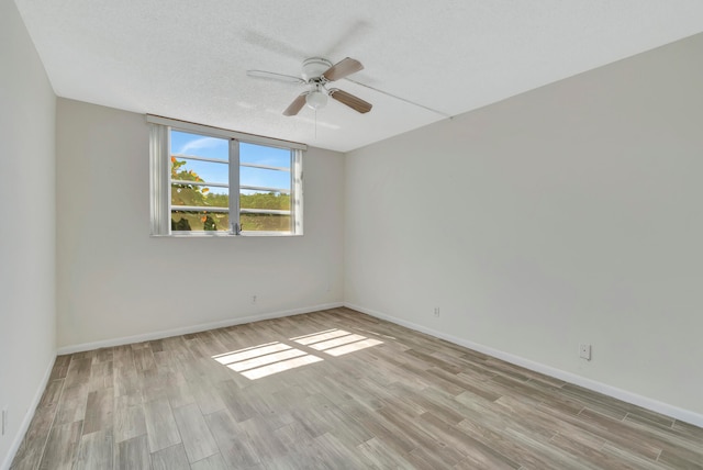 unfurnished room with a textured ceiling, ceiling fan, and light wood-type flooring