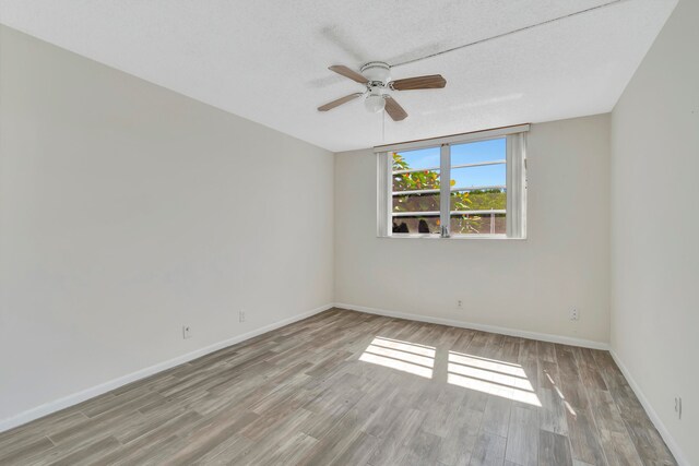 unfurnished room featuring a textured ceiling, ceiling fan, and light hardwood / wood-style floors