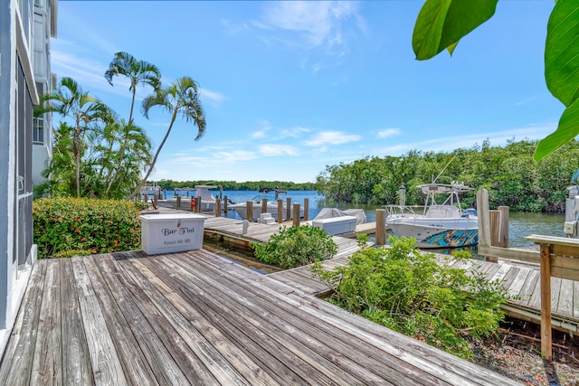 wooden terrace with a water view and a boat dock