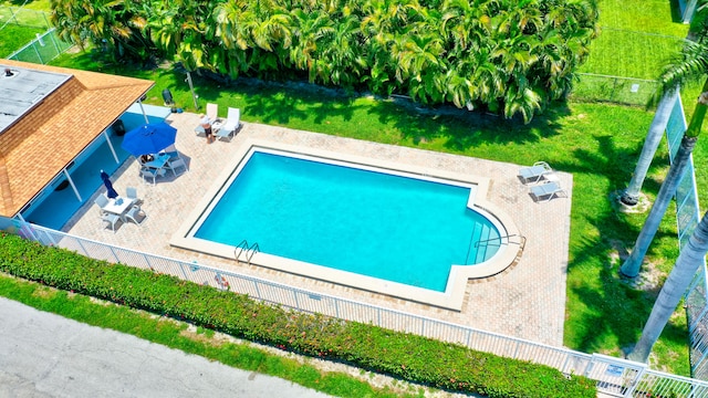 view of swimming pool featuring a yard and a patio area