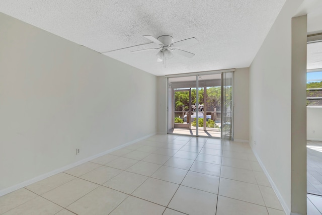 unfurnished room with floor to ceiling windows, ceiling fan, plenty of natural light, and a textured ceiling