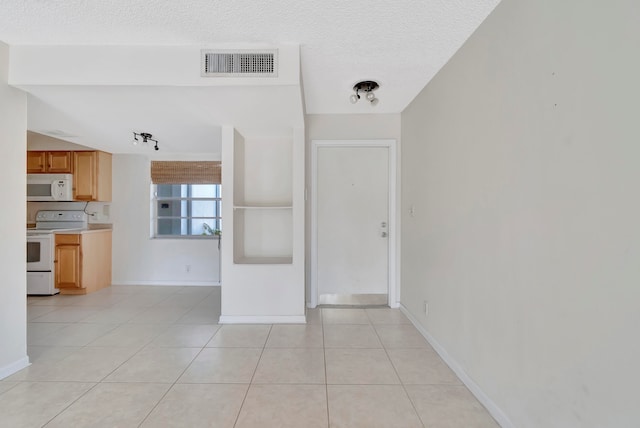 interior space with light tile patterned flooring and a textured ceiling