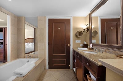 bathroom with vanity, tiled bath, and tile patterned flooring