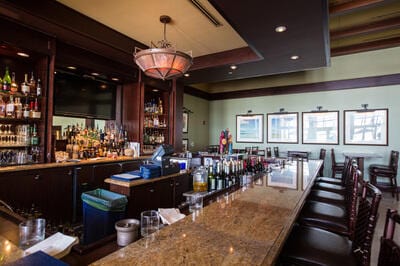 bar featuring pendant lighting and light stone countertops