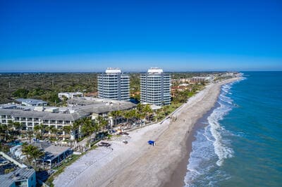 birds eye view of property with a water view and a beach view