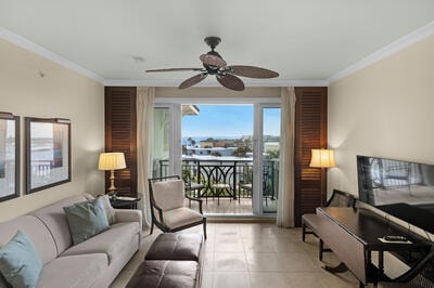 living room with ceiling fan, ornamental molding, tile patterned floors, and brick wall