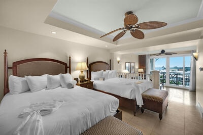 bedroom with ceiling fan, light tile patterned flooring, access to outside, and a tray ceiling