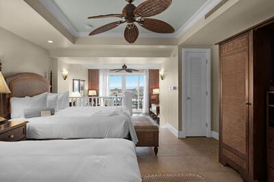 bedroom with ceiling fan, a raised ceiling, and light tile patterned floors