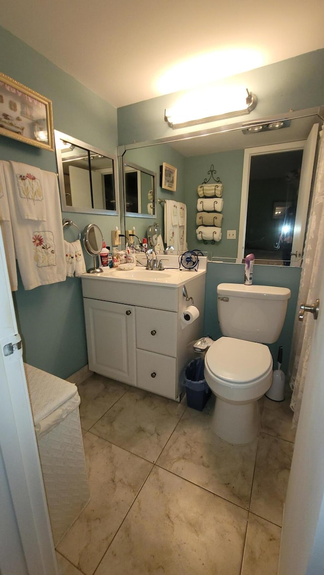 bathroom with vanity, toilet, and tile patterned flooring