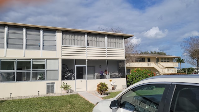 exterior space with a balcony and a front lawn