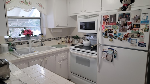 kitchen featuring white appliances, tile countertops, sink, and white cabinets