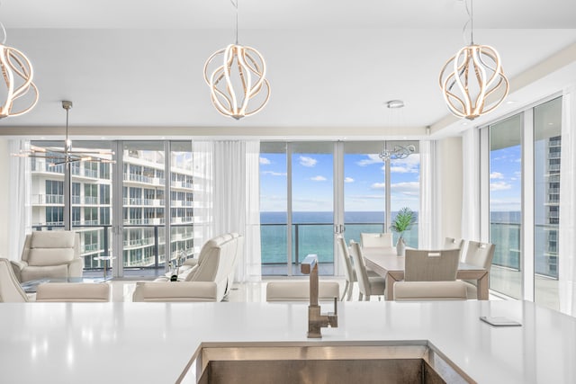 interior space with a water view, an inviting chandelier, and hanging light fixtures