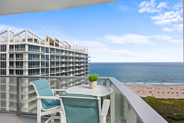 balcony featuring a view of the beach and a water view