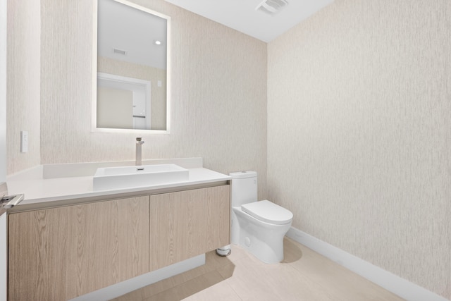 bathroom featuring tile patterned floors, vanity, and toilet