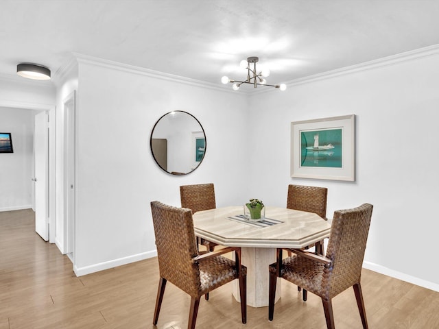 dining space featuring crown molding, a chandelier, and light hardwood / wood-style flooring